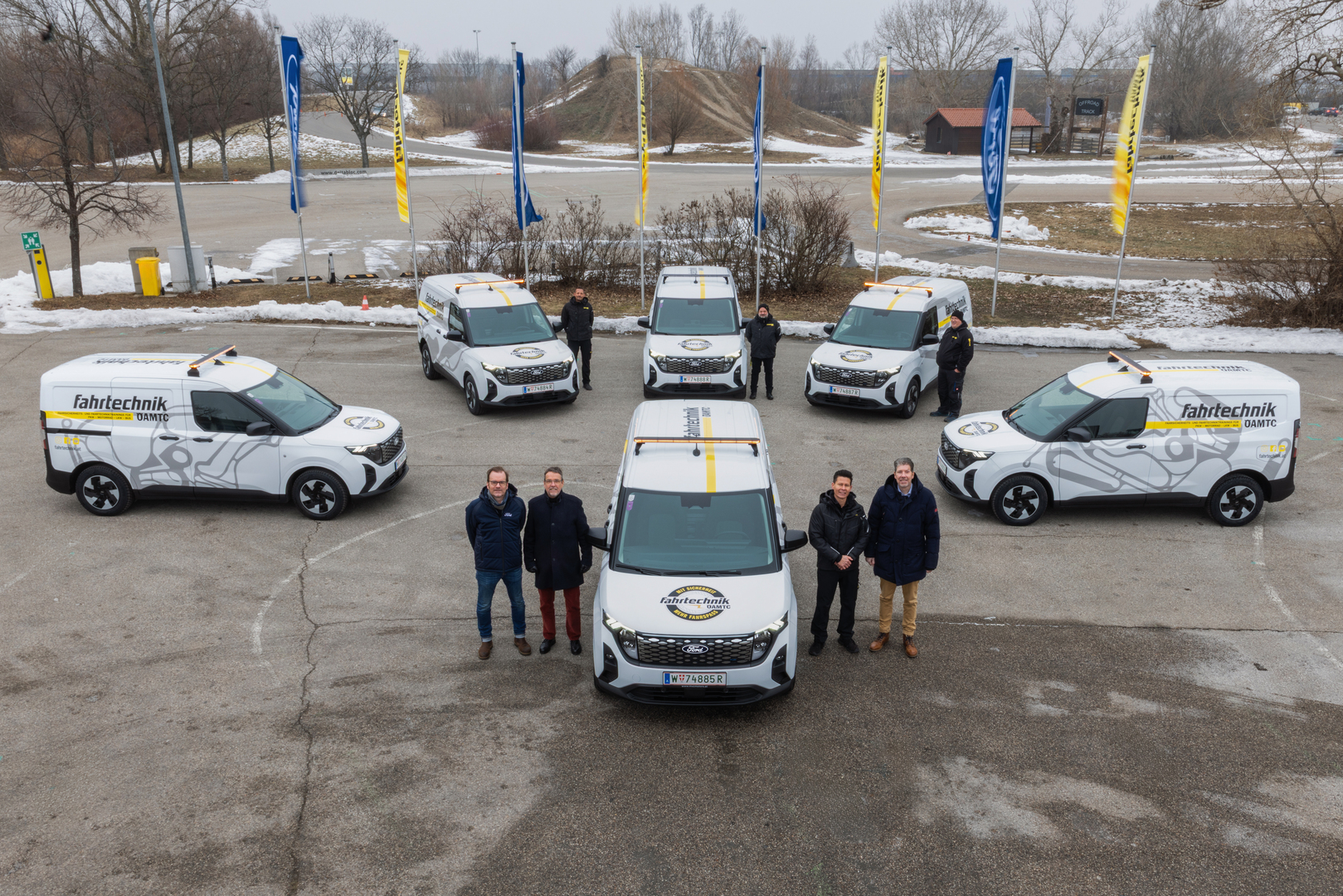 Auf einem Parkplatz im ÖAMTC Fahrtechnikzentrum Teesdorf stehen 6 Ford E-Autos anlässlich der Fahrzeugübergabe mit Vertretern von Ford, Händler MVC Motors Wien-Nord und der ÖAMTC Fahrtechnik.