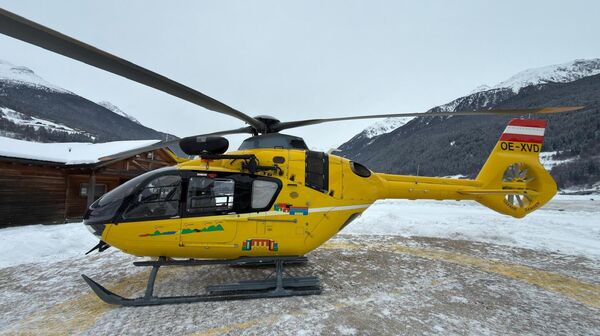 Ein gelber Notarzthubschrauber in winterlicher Landschaft.