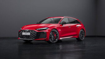 Ein roter Audi RS 5 Avant steht in einem dunklen Studioraum.