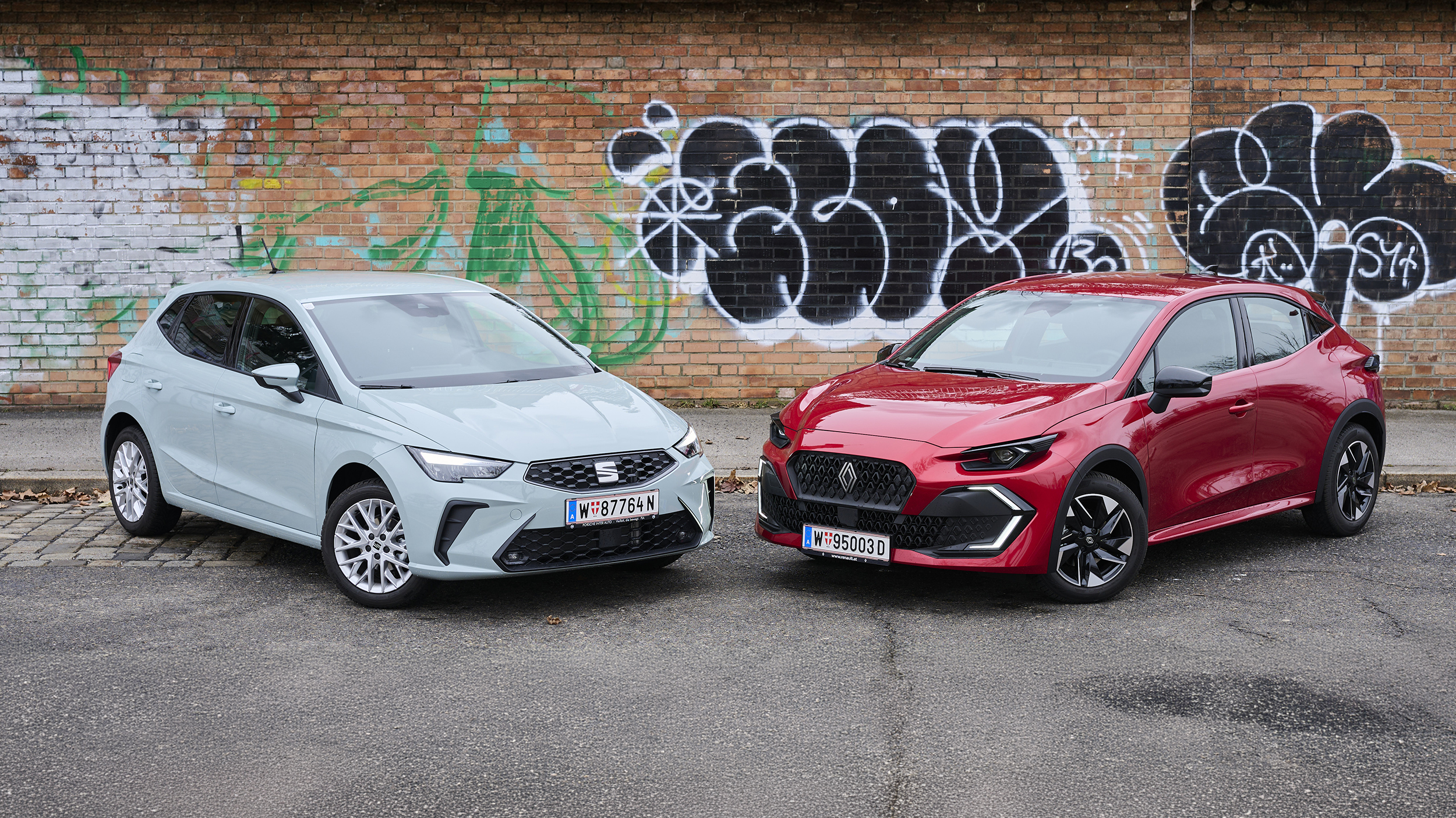 Ein hellgrauer Seat Ibiza steht schräg neben einem roten Renault Clio