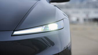 Frontscheinwerfer eines dunkelgrauen Tesla Model Y.