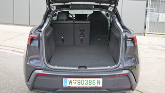 Kofferraum eines dunkelgrauen Tesla Model Y mit umgelegtem rechten Sitz.