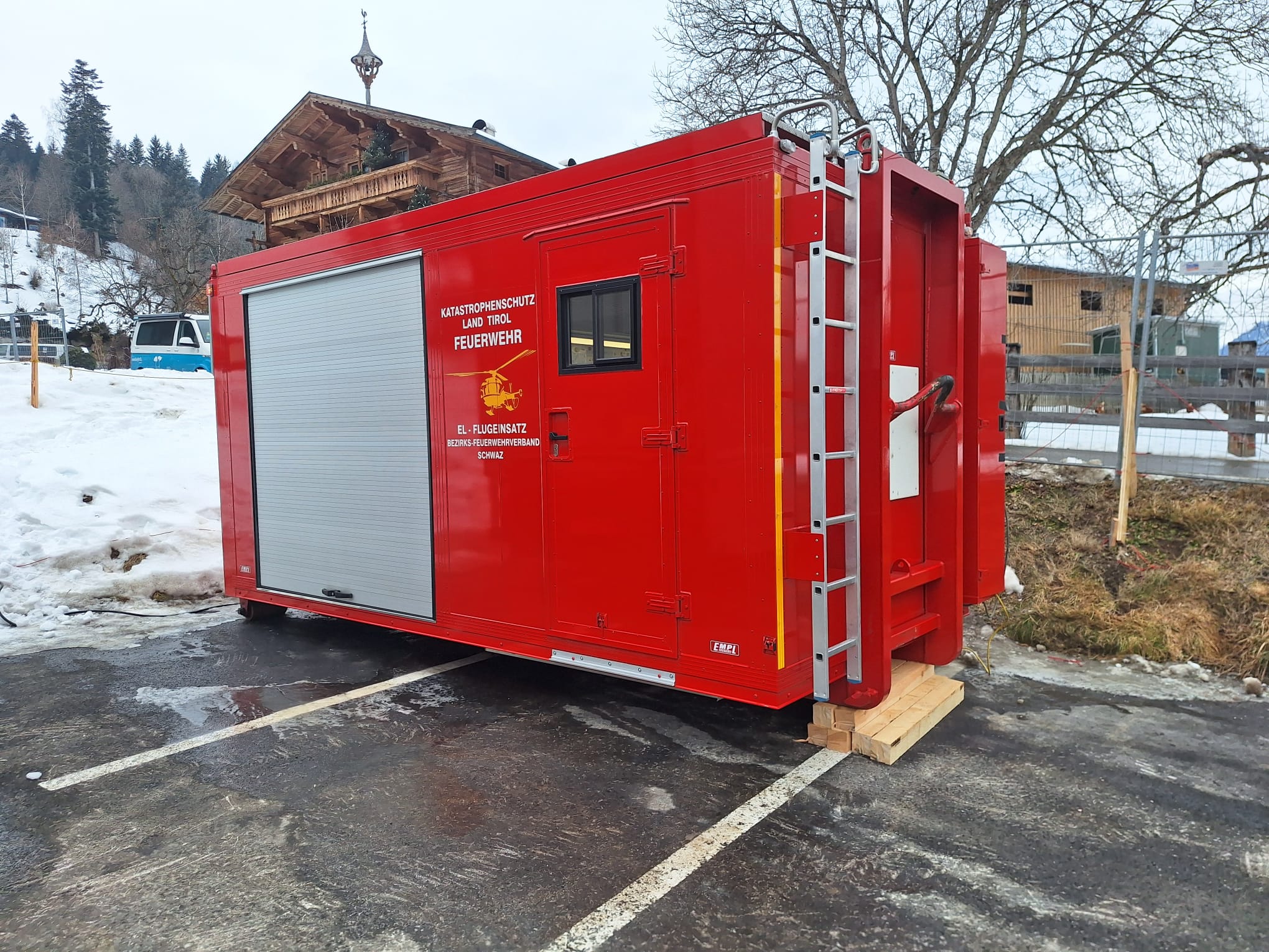 Auf dem Bild sieht man einen roten Container auf einem Prkplatz stehen.