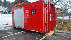 Auf dem Bild sieht man einen roten Container auf einem Prkplatz stehen.