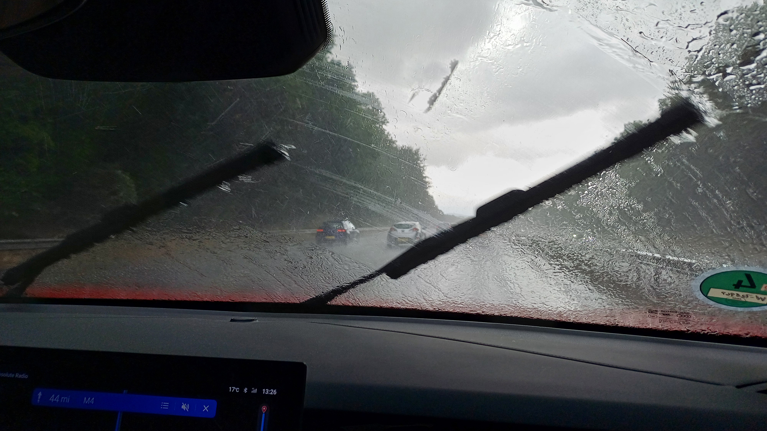 Innenansicht aus einem Auto, während es in Wales in Strömen regnet.
