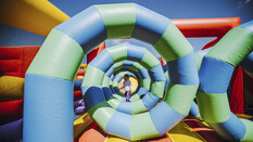 Eine Spirale in einer Hüpfburg, in der Mitte steht ein Kind.