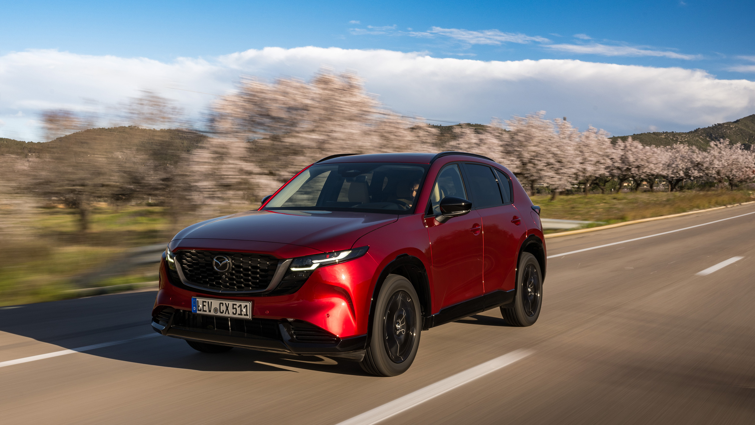 Ein roter Mazda CX-5 fährt auf einer Landstraße