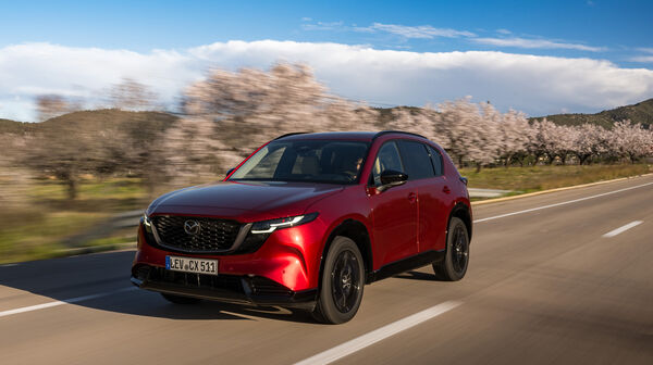 Ein roter Mazda CX-5 fährt auf einer Landstraße