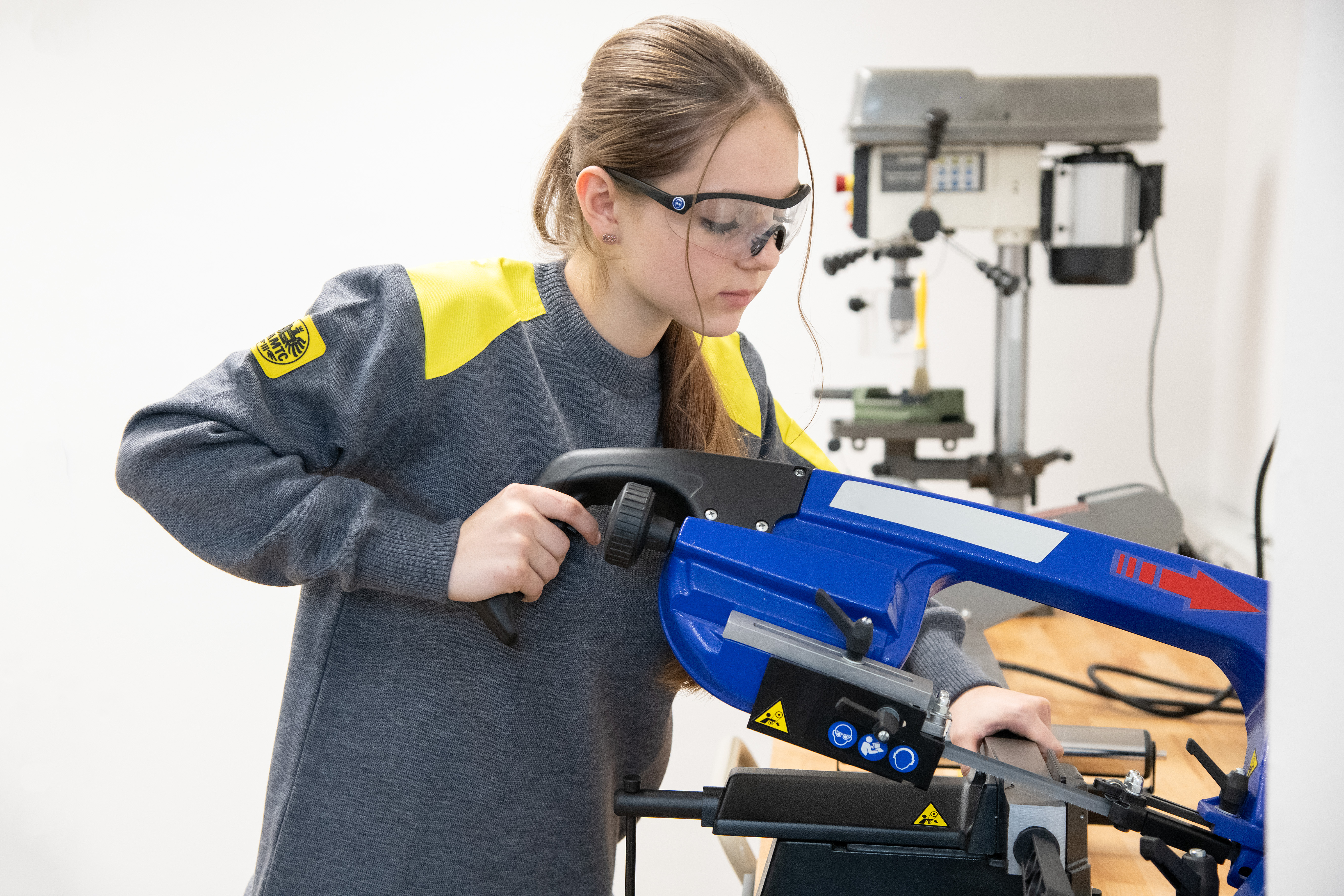 Es ist eine junge Frau zu sehen, die an einem Gerät arbeitet.