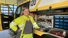 Es ist eine Pannenfahrerin zu sehen, die vor einem geöffnetem Pannenfahrzeug steht.