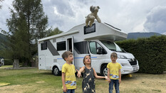 Drei kleine Kinder stehen vor ihrem Wohnmobil.