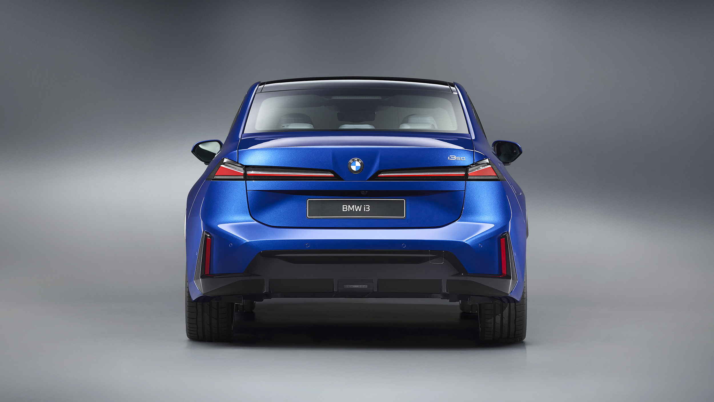 Das Heck eines blauen BMW i3, der in einem Studio steht.
