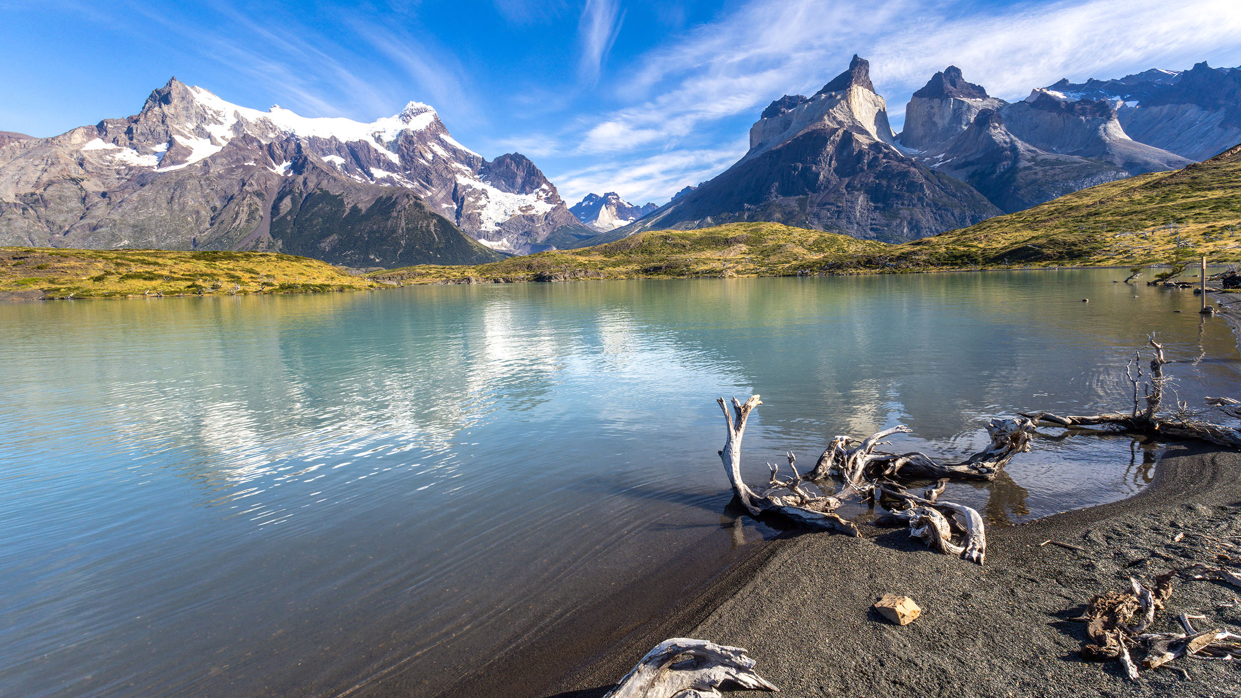 Blick über einen grünen See zum Bergmassiv Cuernos del paine