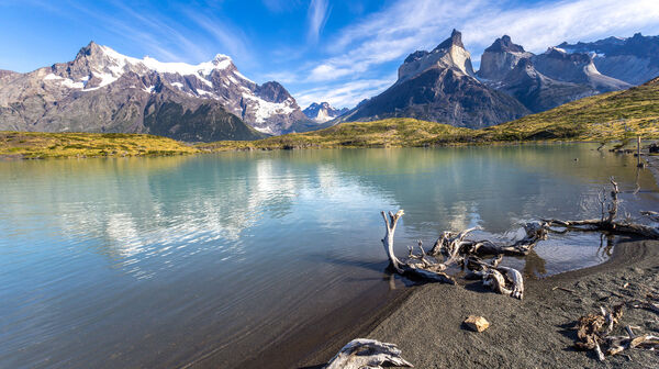 Blick über einen grünen See zum Bergmassiv Cuernos del paine