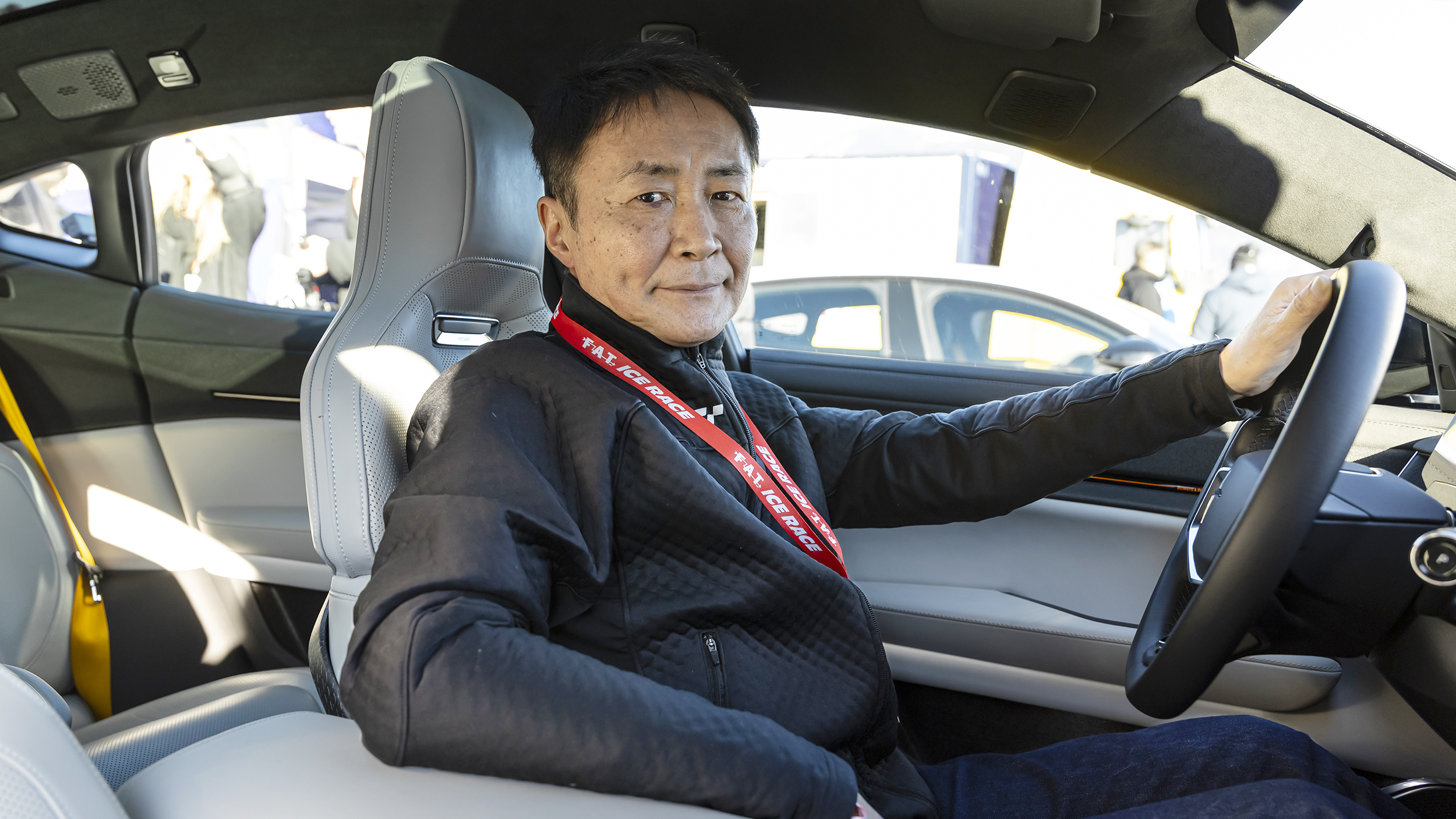 Kazunori Yamauchi im Auto am Steuer, er lächelt in die Kamera.