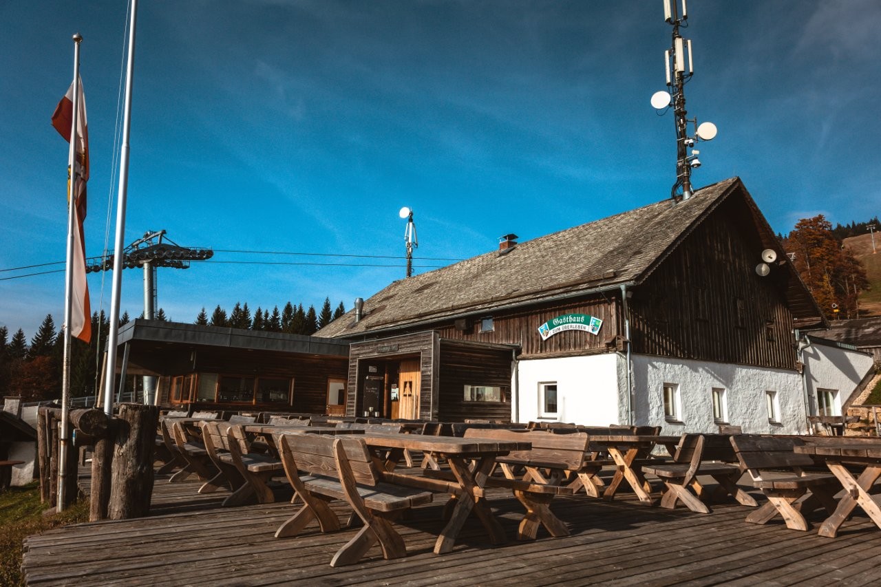 Auf dem Bild sieht man ein Gasthaus mit einem Handymasten auf dem Dach.