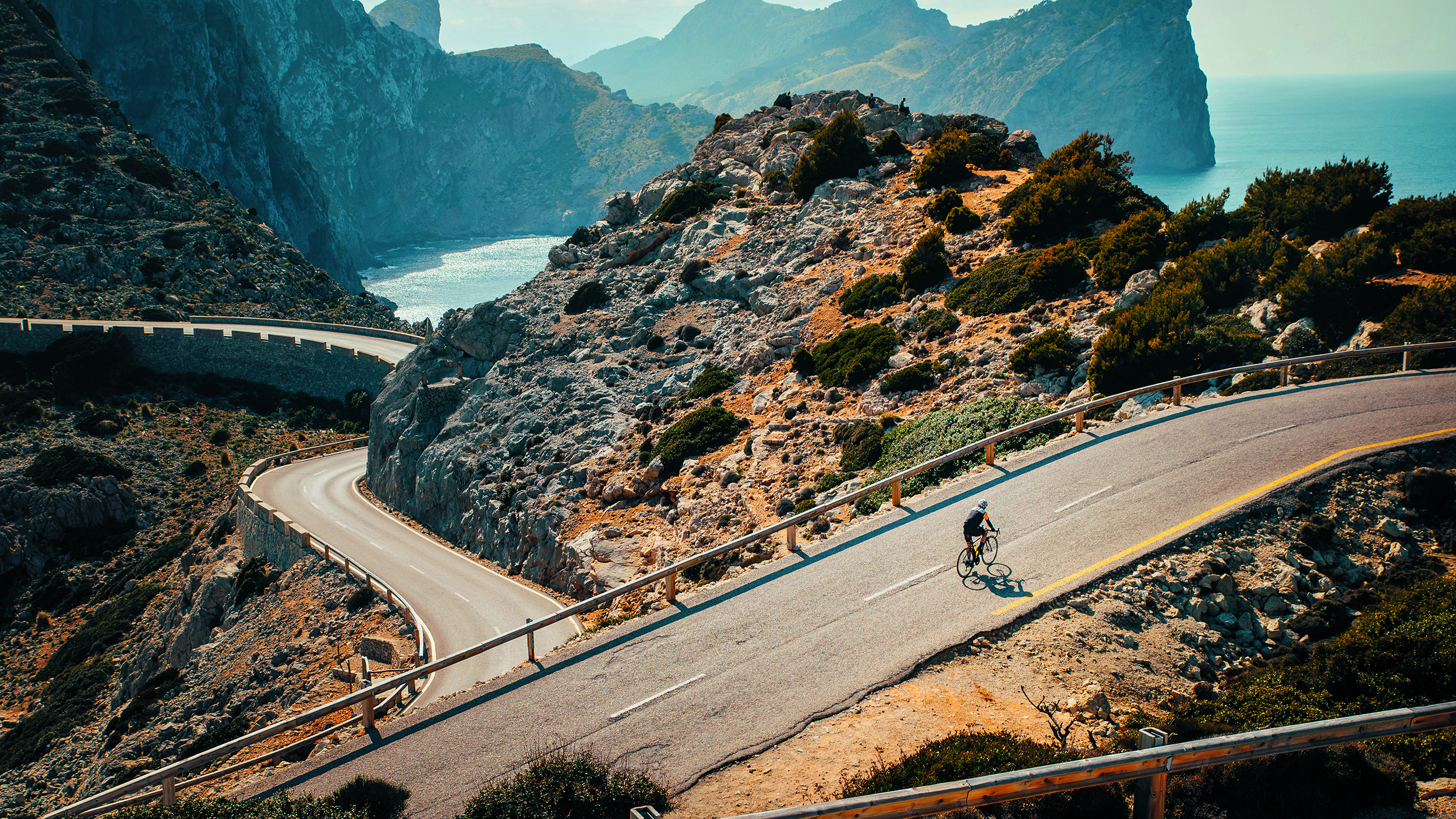 Ein Radfahrer auf einer mediterranen Bergstraße.
