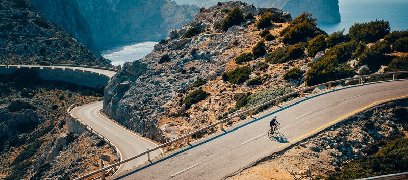 Ein Radfahrer auf einer mediterranen Bergstraße.