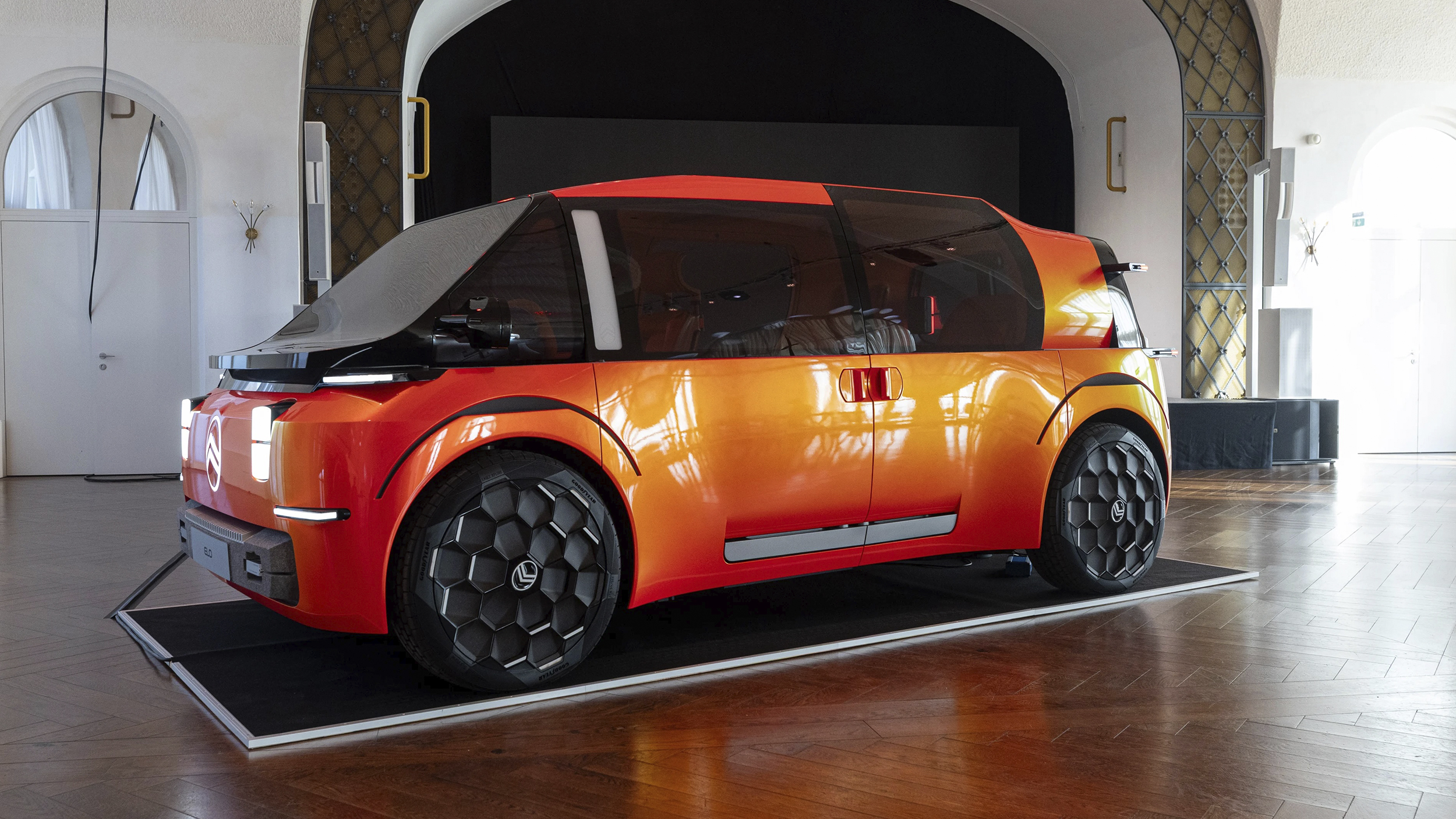 Der Citroen Elo. Er ist Orange, seitlich fotografiert. Er ist sehr futuristisch.