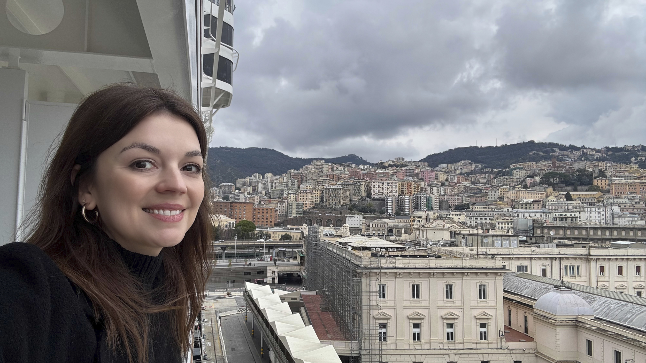 Die Redakteurin Amélie auf der MSC World Europa. Blick von dem Balkon auf die Stadt Genua.
