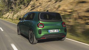 Ein grüner Renault Twingo fährt über eine Landstraße.