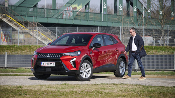 Mitsubishi Grandis in roter Farbe, schräge Ansicht mit Redakteur Christian Stich