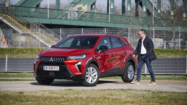 Mitsubishi Grandis in roter Farbe, schräge Ansicht mit Redakteur Christian Stich