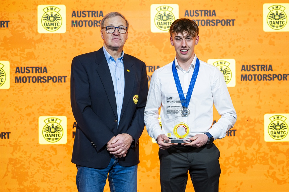 Das Bild zeigt zwei Personen. eine davon hält einen Preis in der Hand.