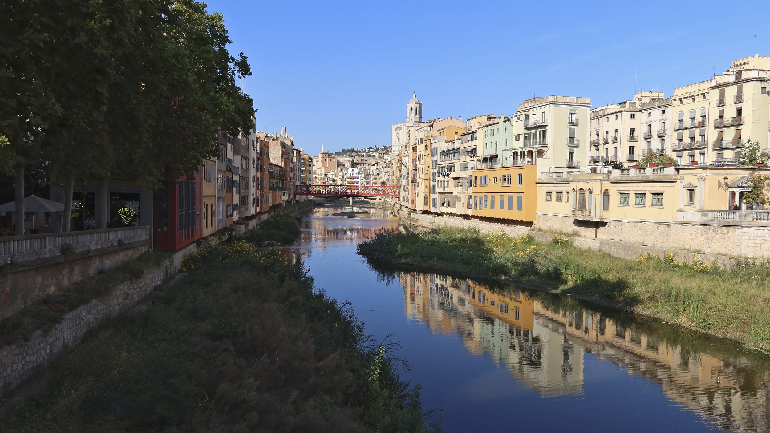Blick auf den Fluss Onyar in Girona mit bunten Häusern am Uferrand.