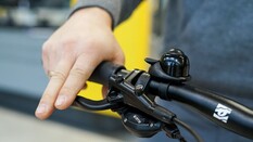 Auf dem Bild sieht man eine Hand, die den Bremsgriff eines Fahrrads bedient.