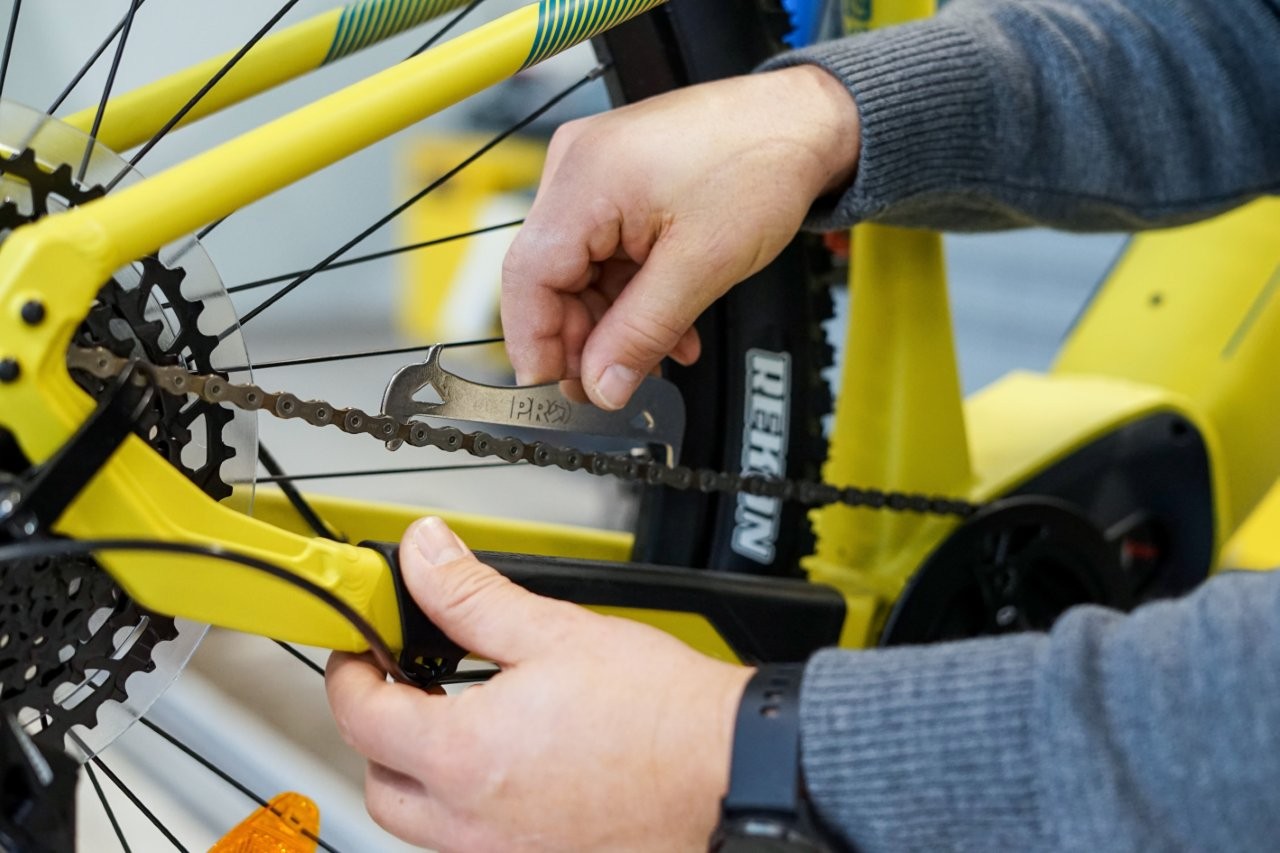 Auf dem Bild sieht man eine Hand die den Abstand der einzelnen Kettenglieder mißt.