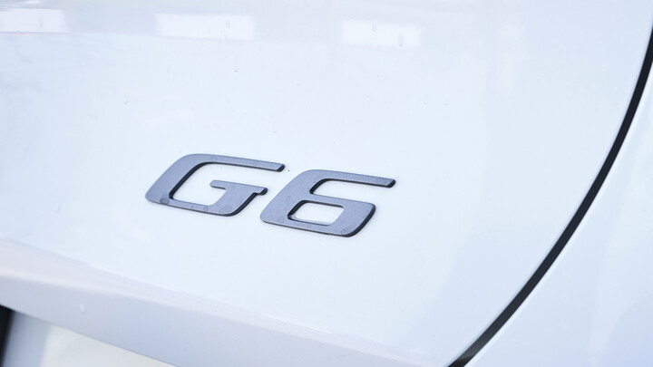 G6-Schriftzug in Chrom am Heck eines weißen Xpeng G6.