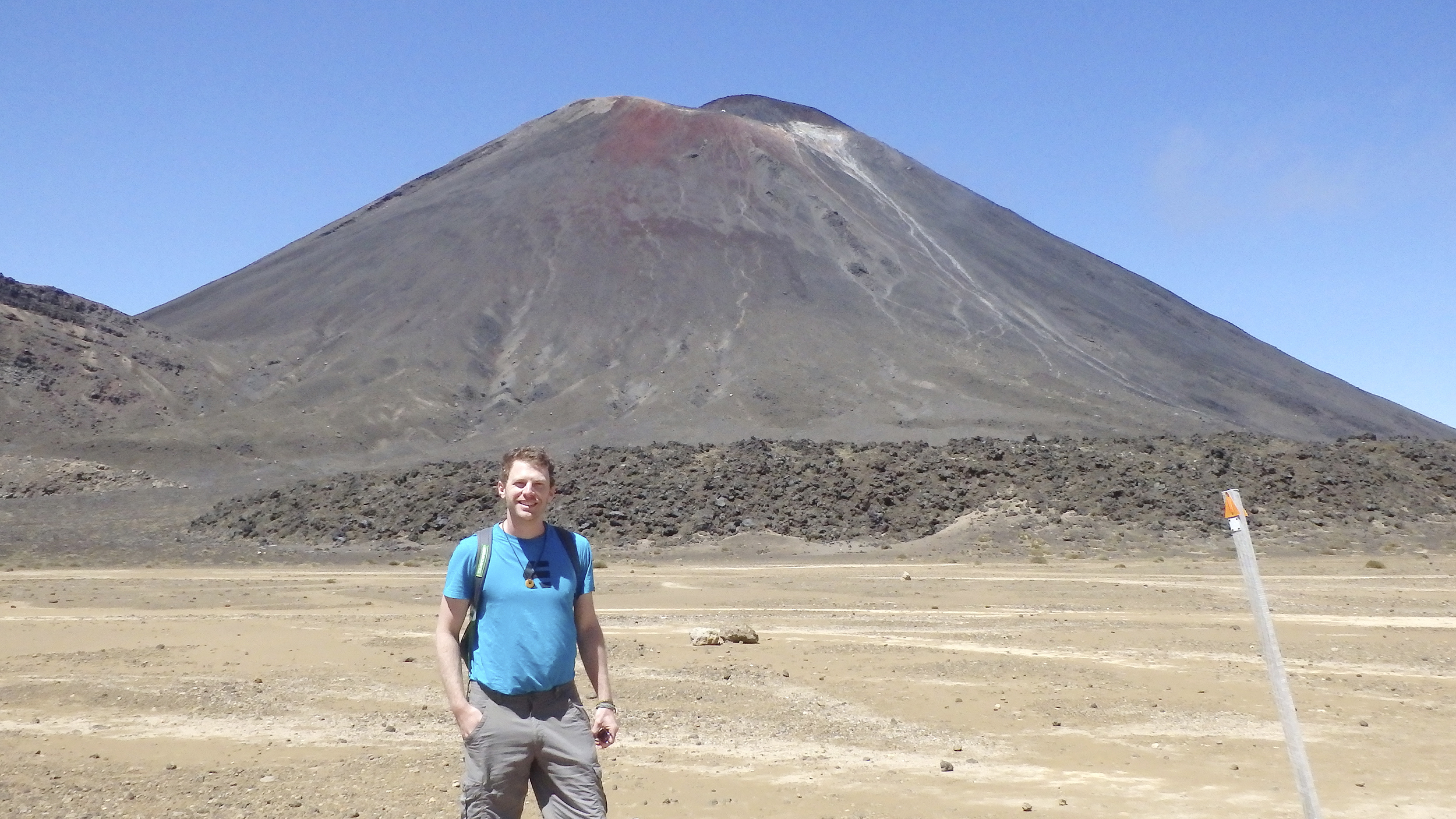 Ein Mann steht vorm Vulkan Mt. Nagauruhoe.