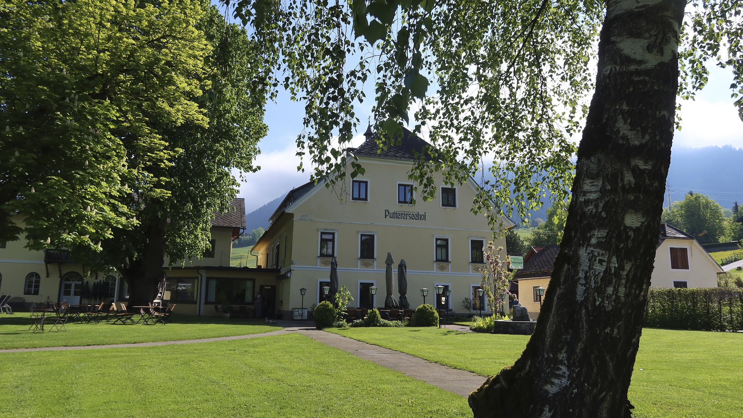 Aufnahme von außen vom Gut Puttererseehof hinter einem Baum.