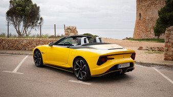 Ein gelber MG Cyberster steht auf einem Parkplatz am Meer.