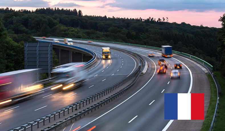 Eine Autobahn mit fahrenden Autos in der Dämmerung in Frankreich