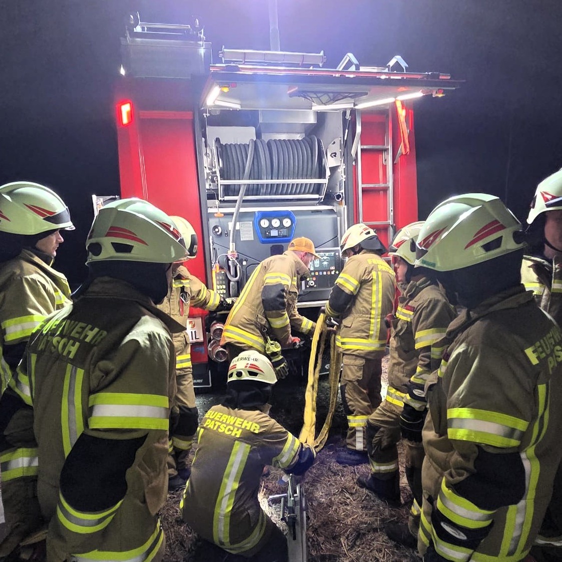 Auf dem Bild sieht man viele Feuerwehrmänner und Frauen im Einsatz vor einem Fahrzeug der Feuerwehr