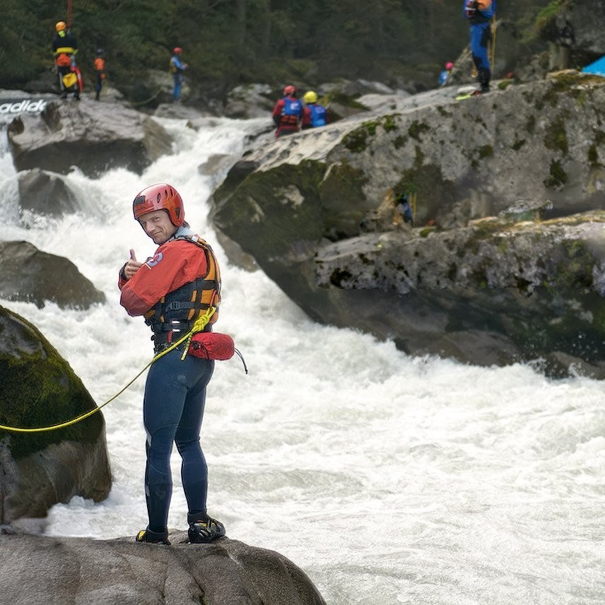 Auf dem Bild sieht man einen Mitarbeiter der Wasserrettung vor einem reißenden Fluß.