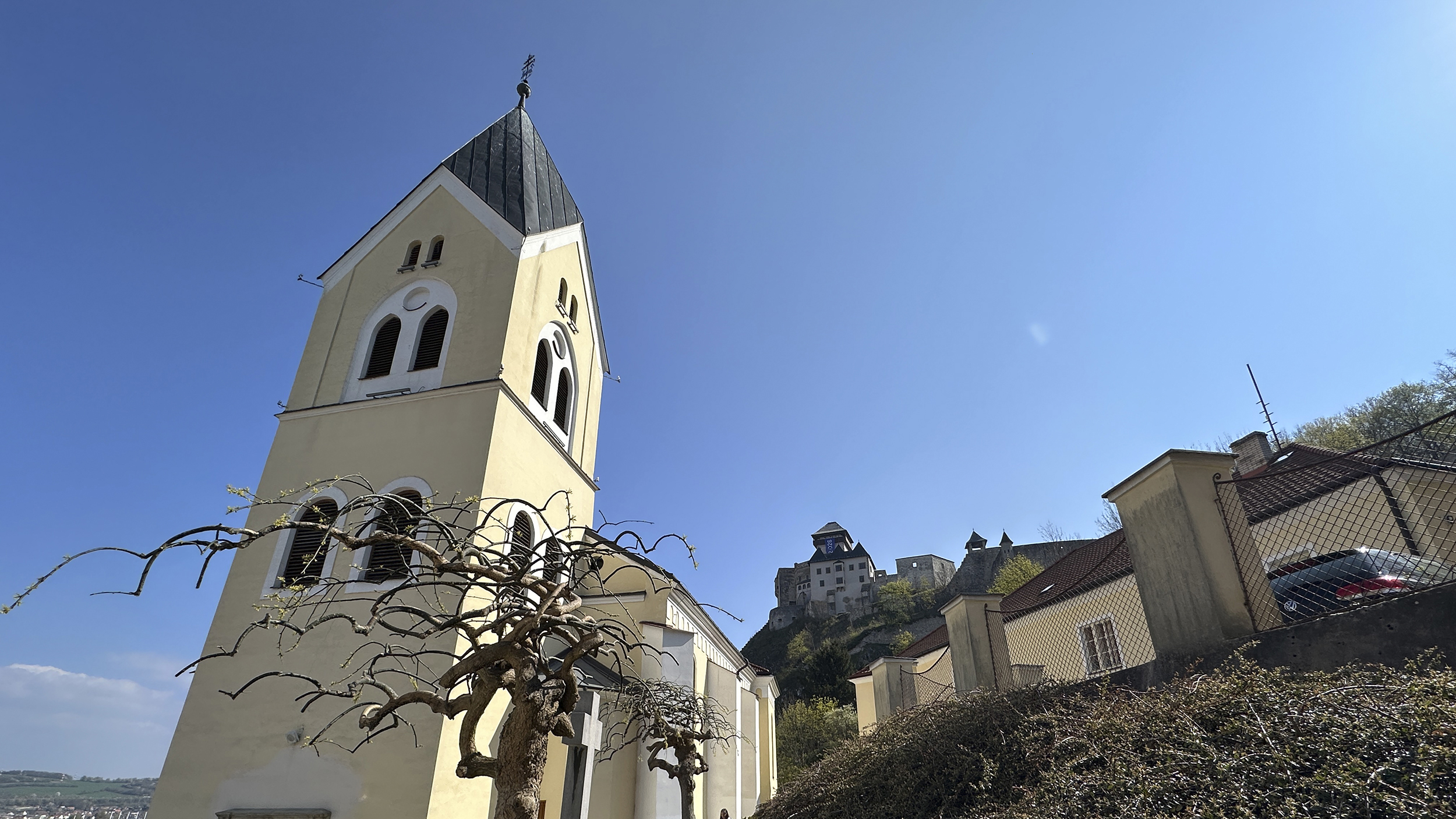 Oben angekommen steht man vor einer gelben Kirche.