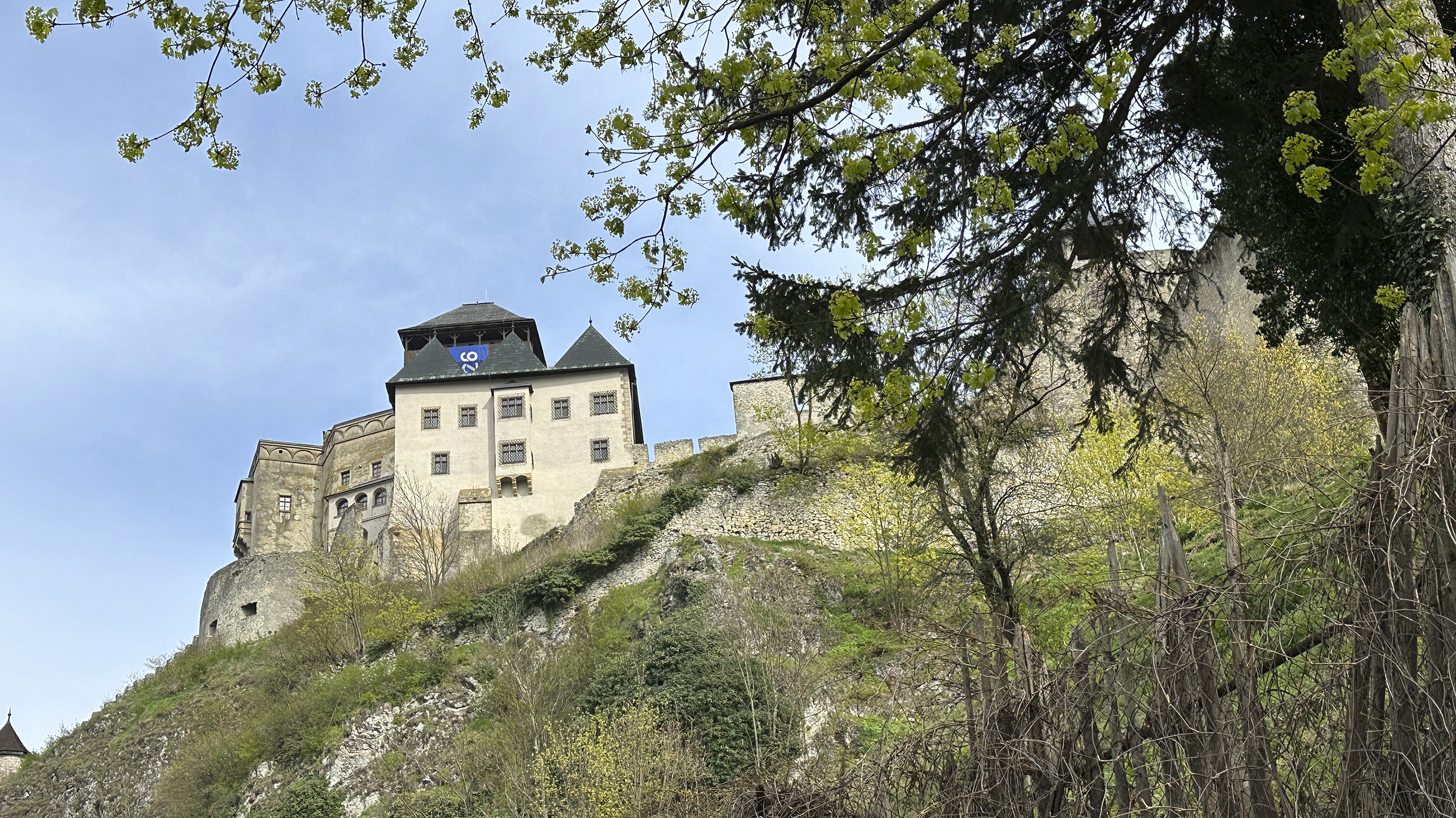 Eine großteils bereits restaurierte Burg thront auf einem Felsen.