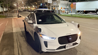 Ein weißes autonomes Taxi bei Nacht