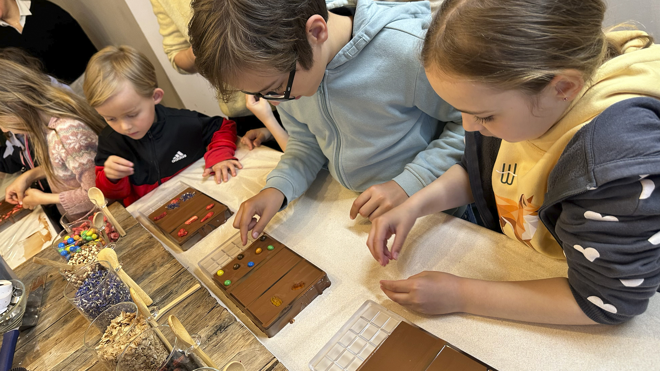 Kinder verzieren Schokoladetafeln.