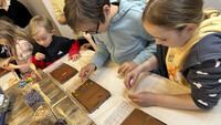 Kinder verzieren Schokoladetafeln.