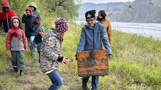 Ein Kind mit Piratentuch trägt eine Schatzkiste, rundherum mehrere Menschen.