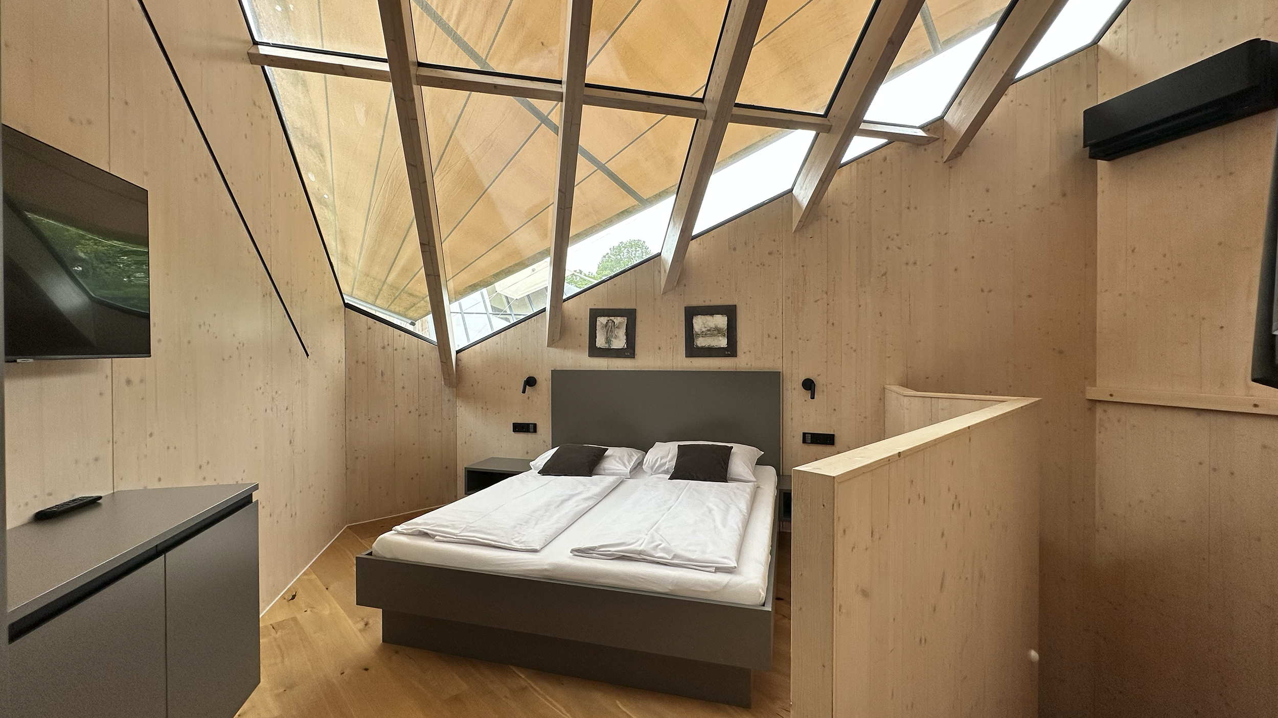 Schlafzimmer im Sternenhimmel-Chalet im Ikuna. Oben große Glasfenster.