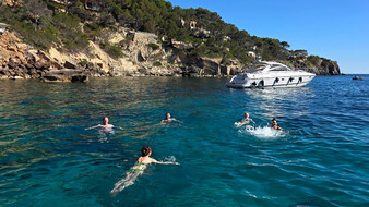 ein paar Personen schwimmen in einer bucht im meer.