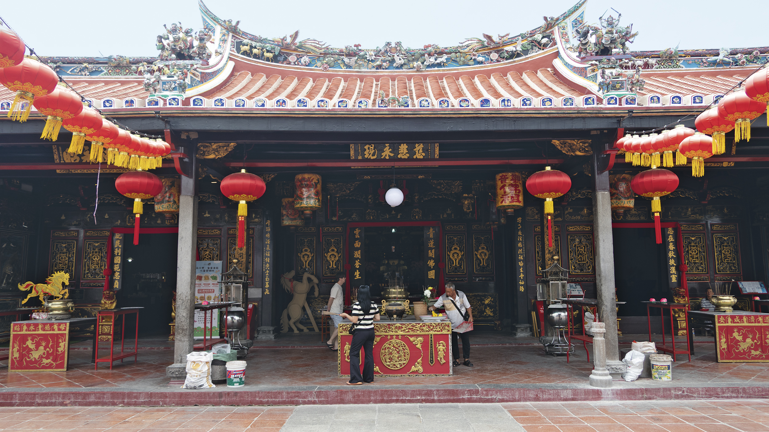 Ein chinesischer Tempel, vor dem Personen stehen.