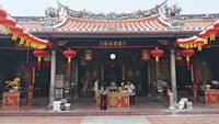 Ein chinesischer Tempel, vor dem Personen stehen.