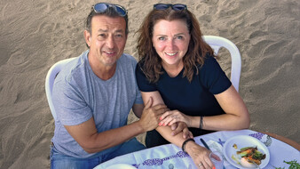Ein Ehepaar sitzt gemeinsam in einem Strandcafe.