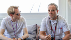 Ein Journalist und Rubens Barrichello sitzen auf einer Couch.